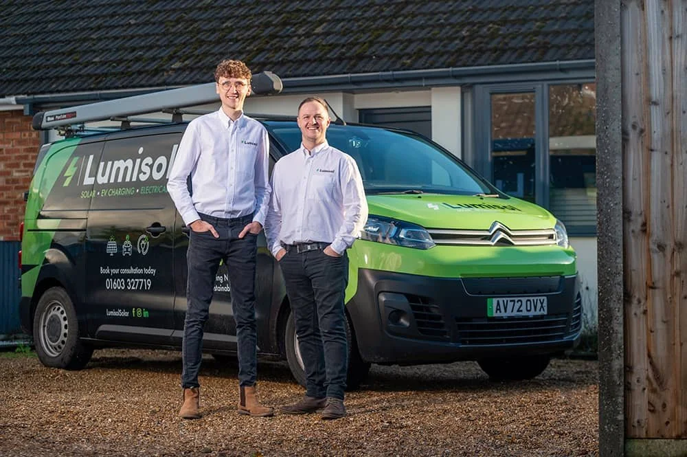 Two directors of Lumisol electrical company standing in front of branded van in Norwich