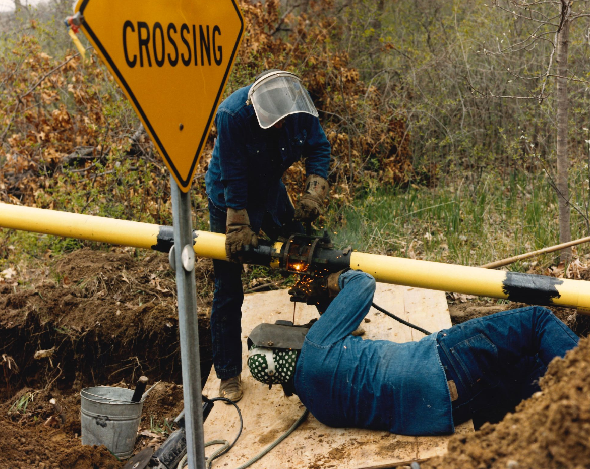 A photo of a welder working on a butt weld for a gas distribution pipeline