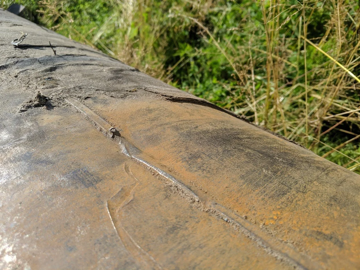 Rusted pipeline needing remediation in field