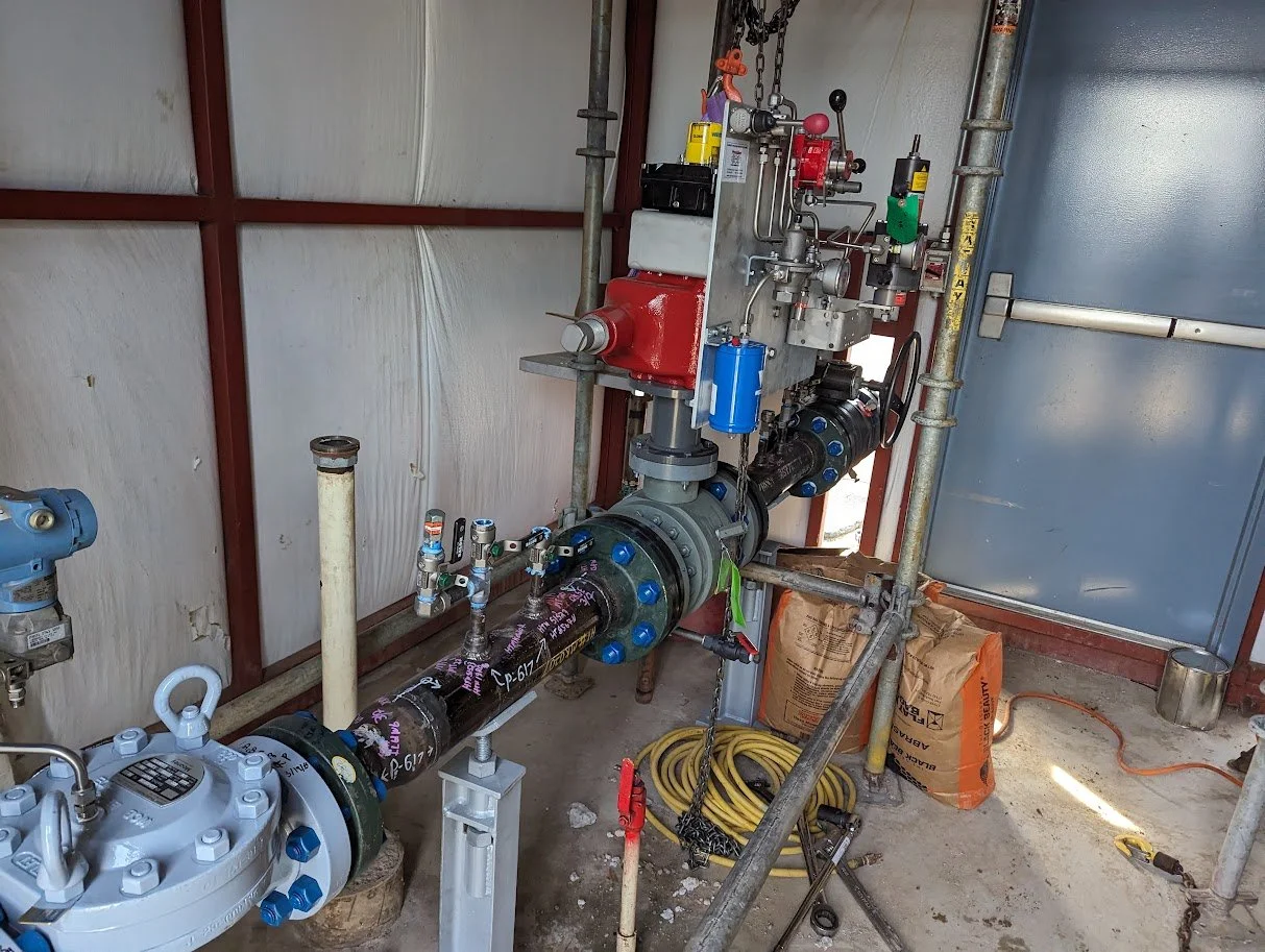 R.L. Coolsaet district regulation equipment with valves and gauges in a storage room.