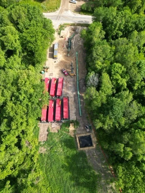 R.L. Coolsaet hydrostatic test site with pipeline and equipment in forest area.