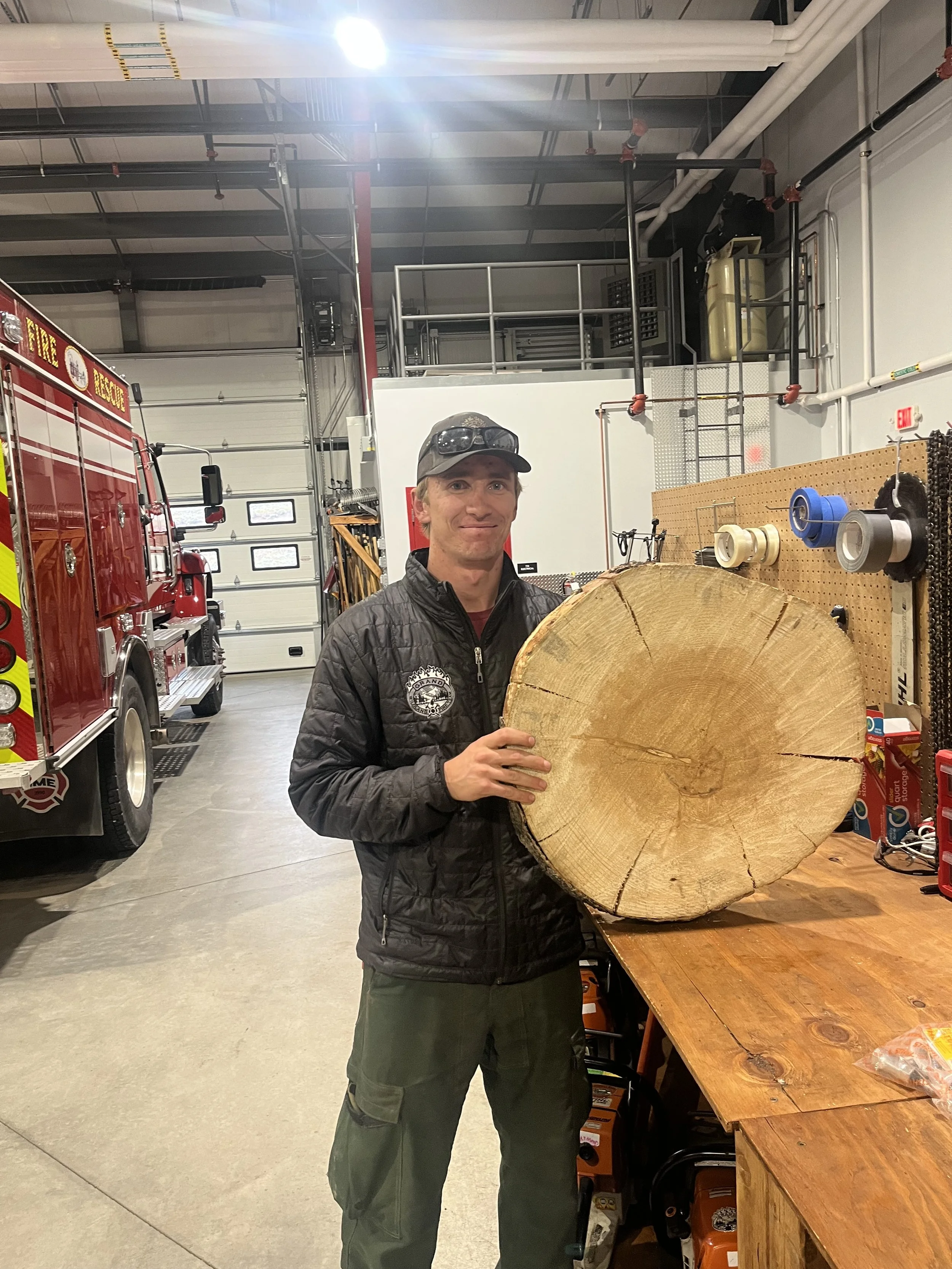 Photo of Jacob Schauer holding a tree trunk cross section.