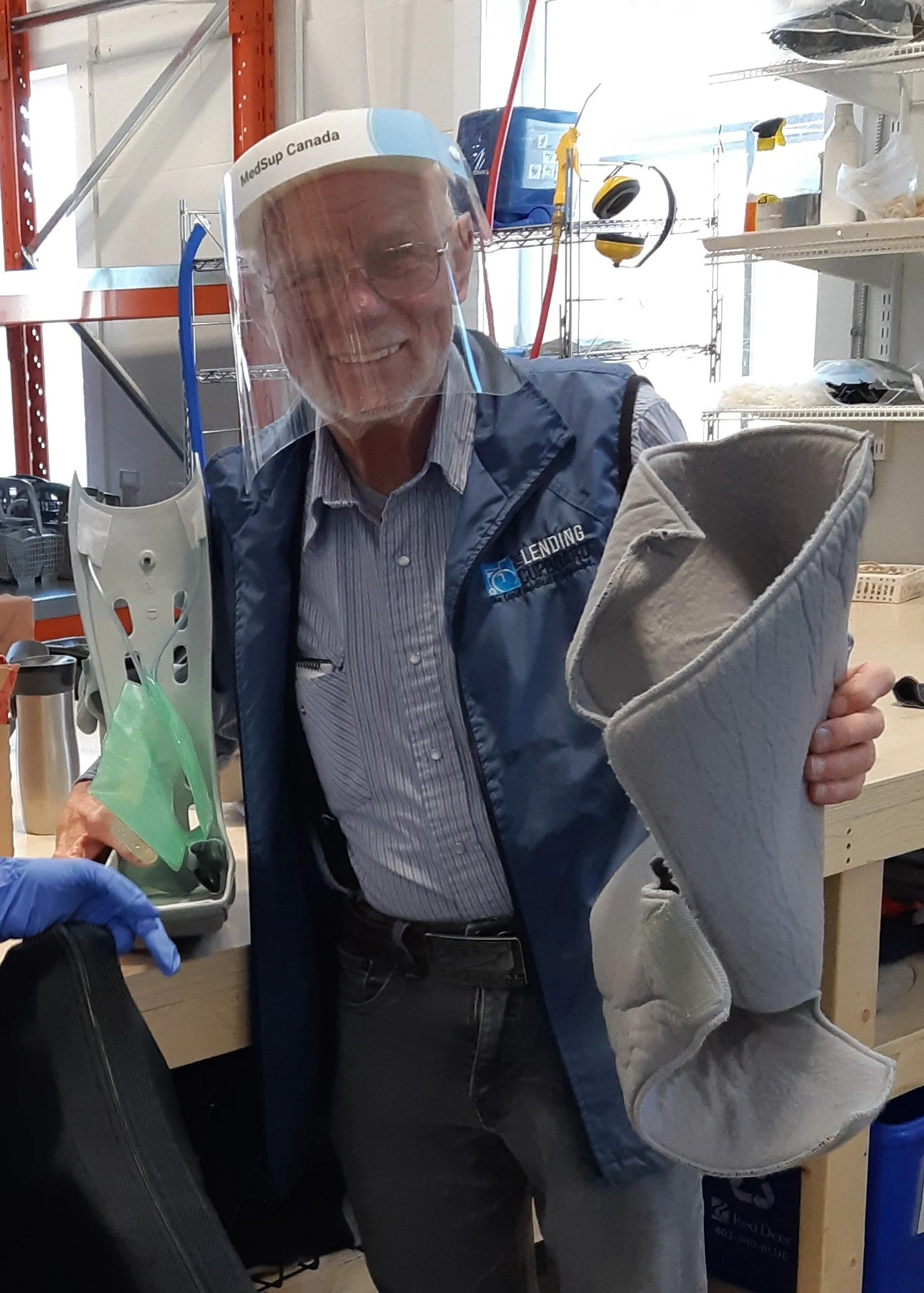 Kiffer smiling while holding a medical air boot that he repairs for The Lending Cupboard®.