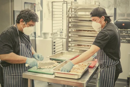 Masked kitchen workers in aprons