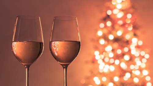 wine glasses in front of christmas trees
