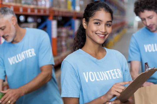 smiling female volunteer with two men do inventory