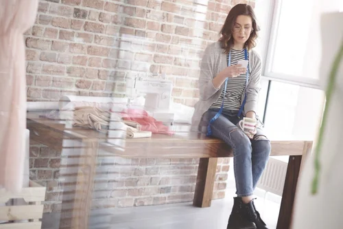 young woman looks at smartphone