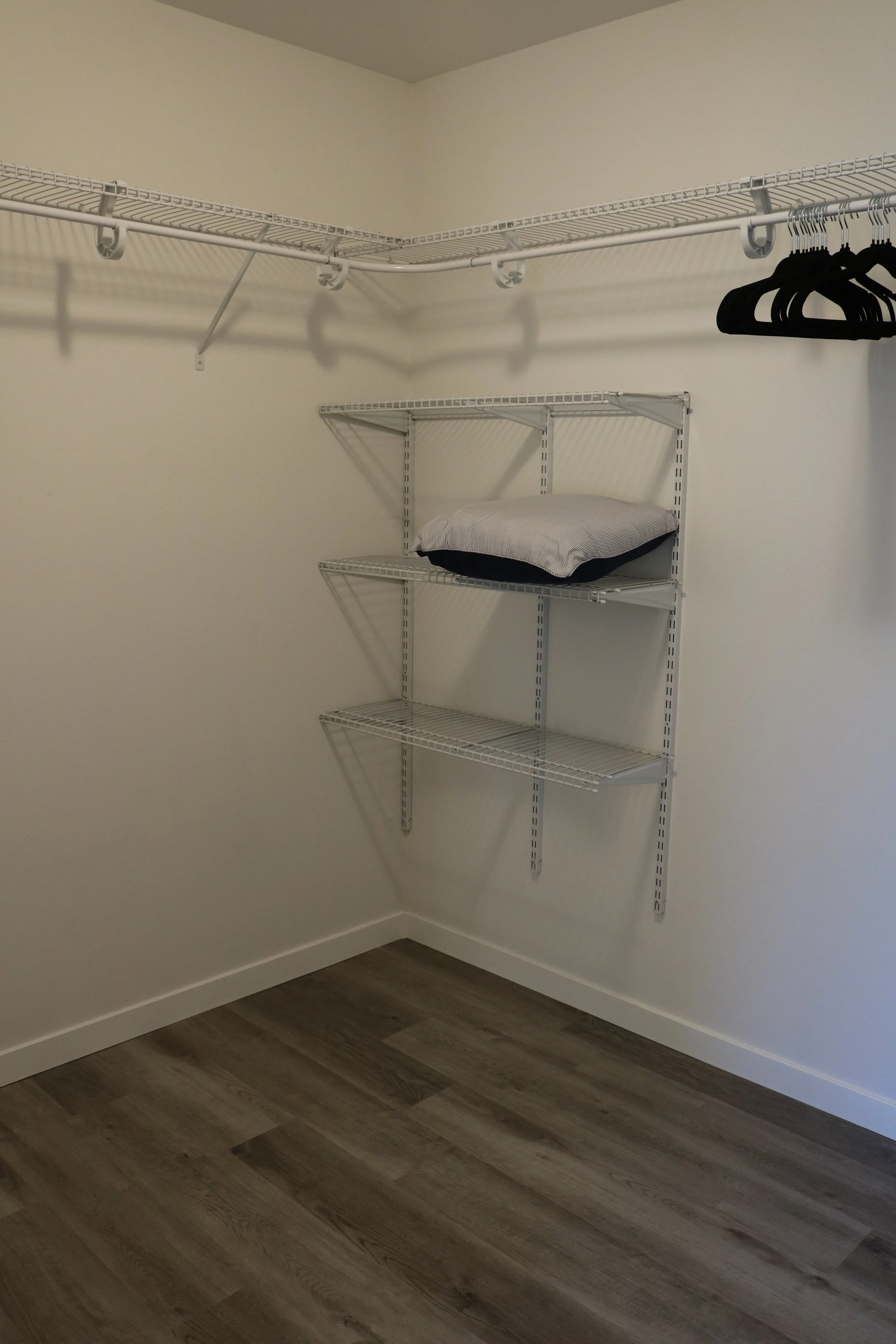 Empty walk-in closet with wire shelving and hangers.
