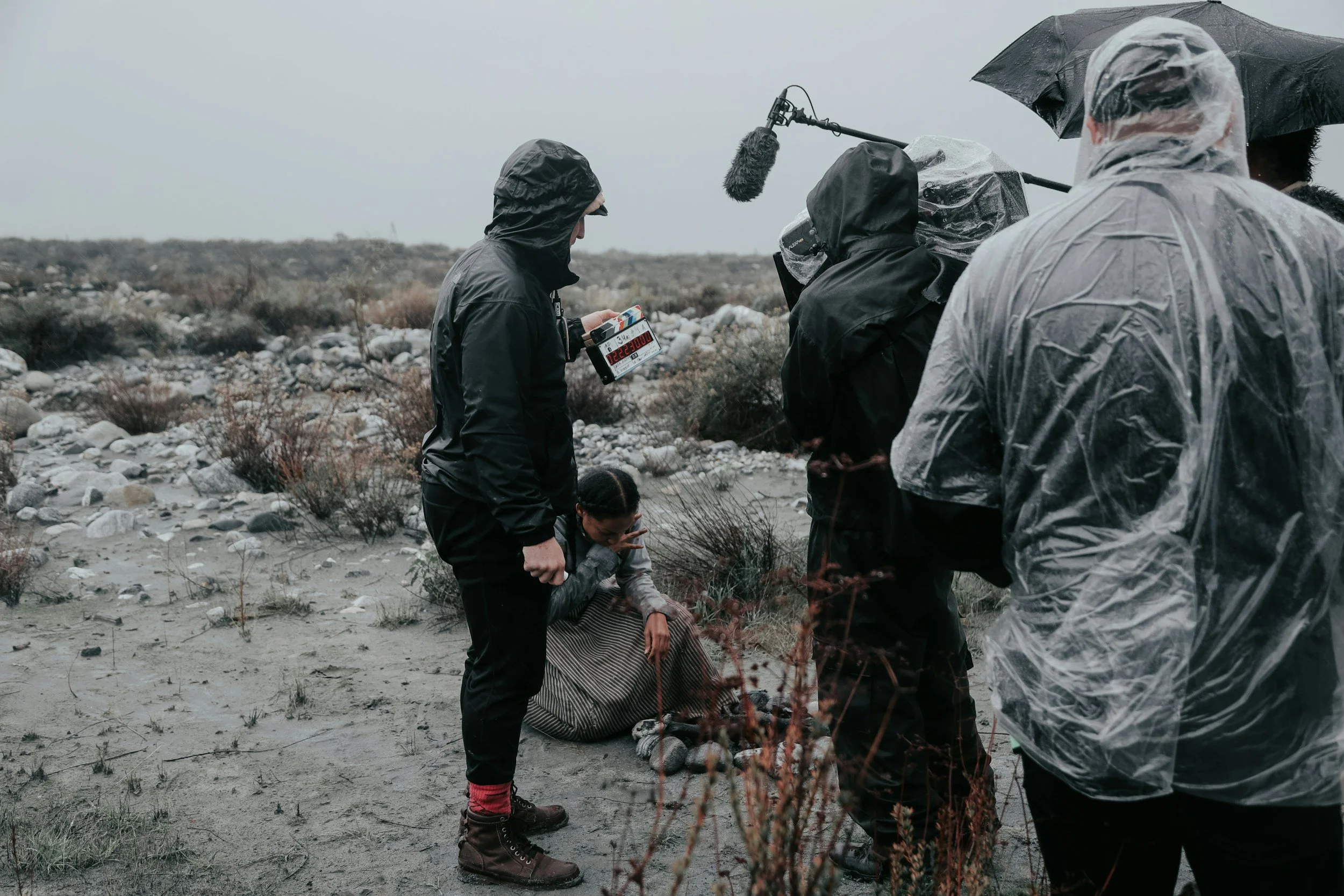 Filmmaker operating camera during on-location shoot in harsh conditions