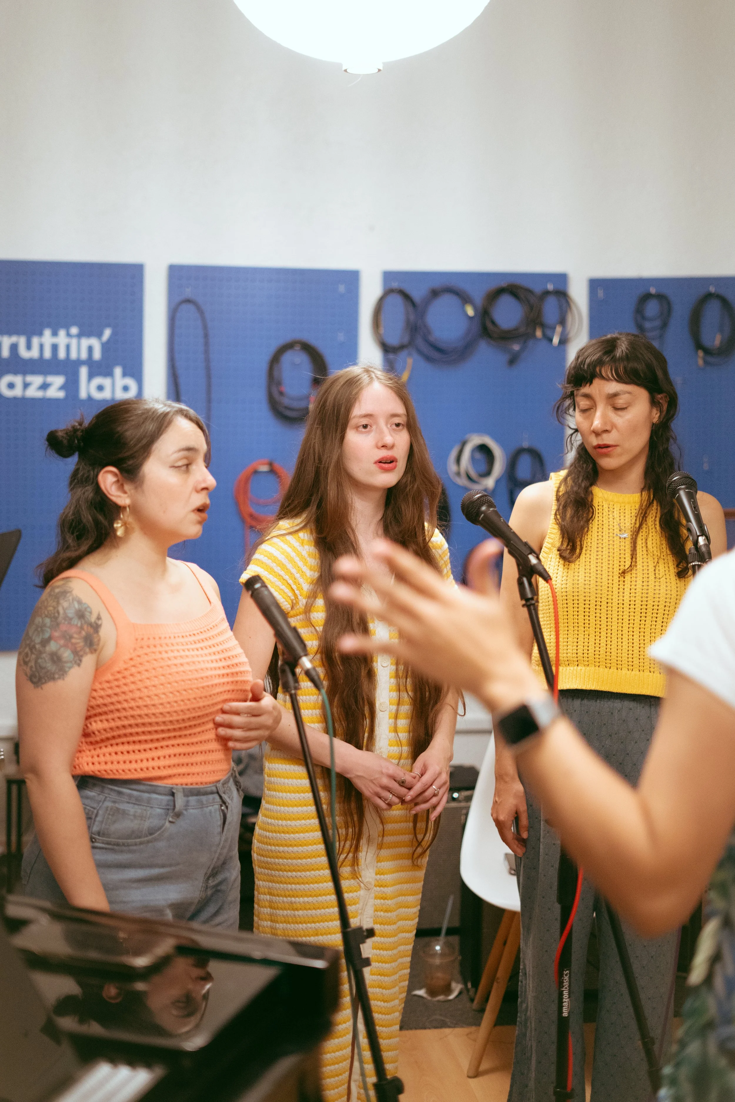 A person holding an alto saxophone, with only the upper body visible against a dark background.