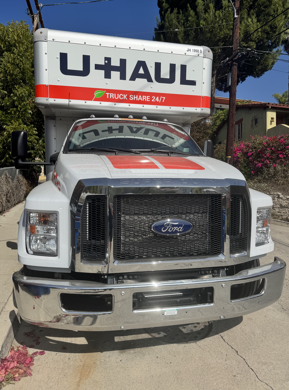 The front of a U-Haul moving truck parked on a residential street.