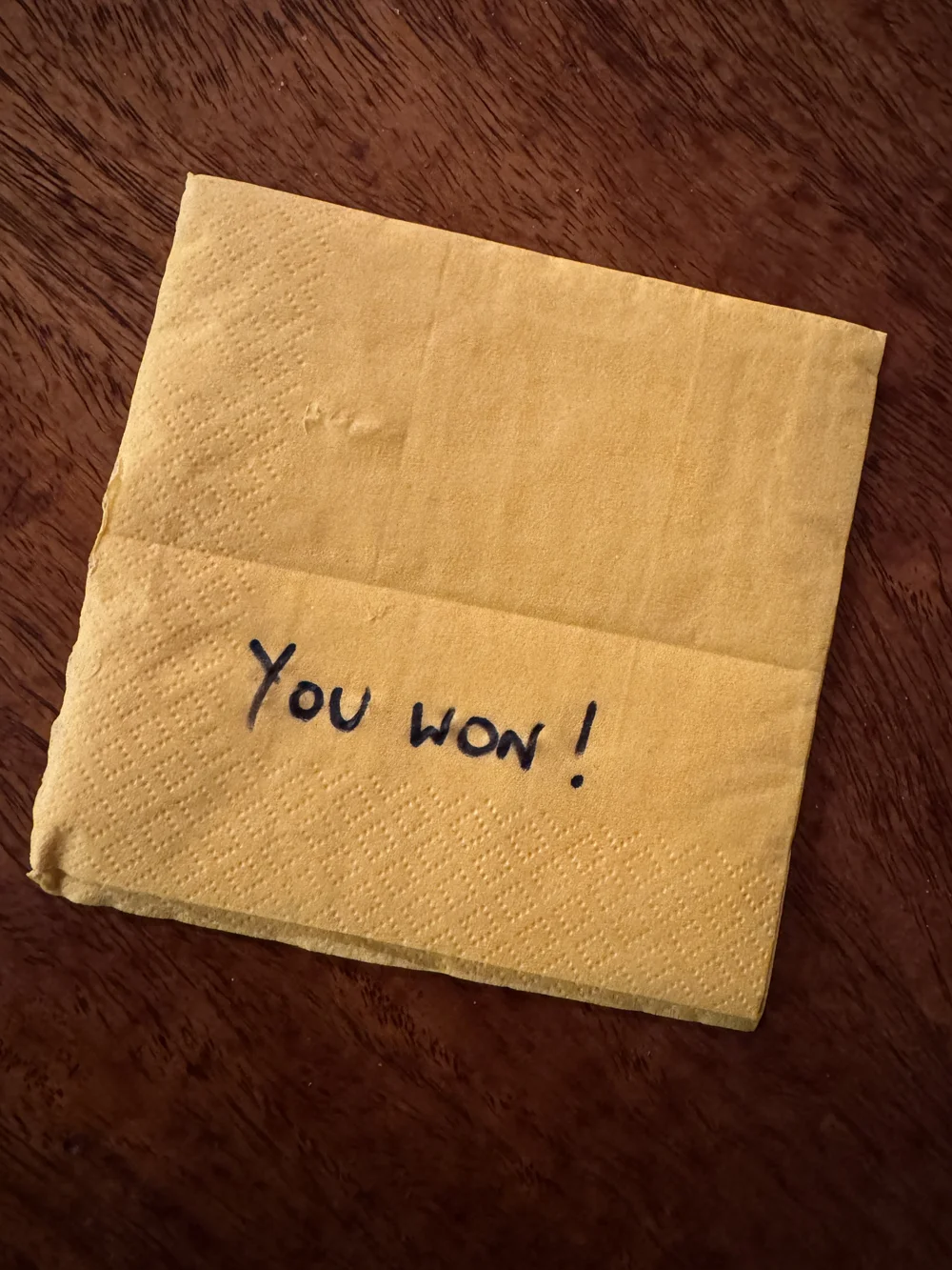 A folded bar napkin with 'You won!' handwritten on it