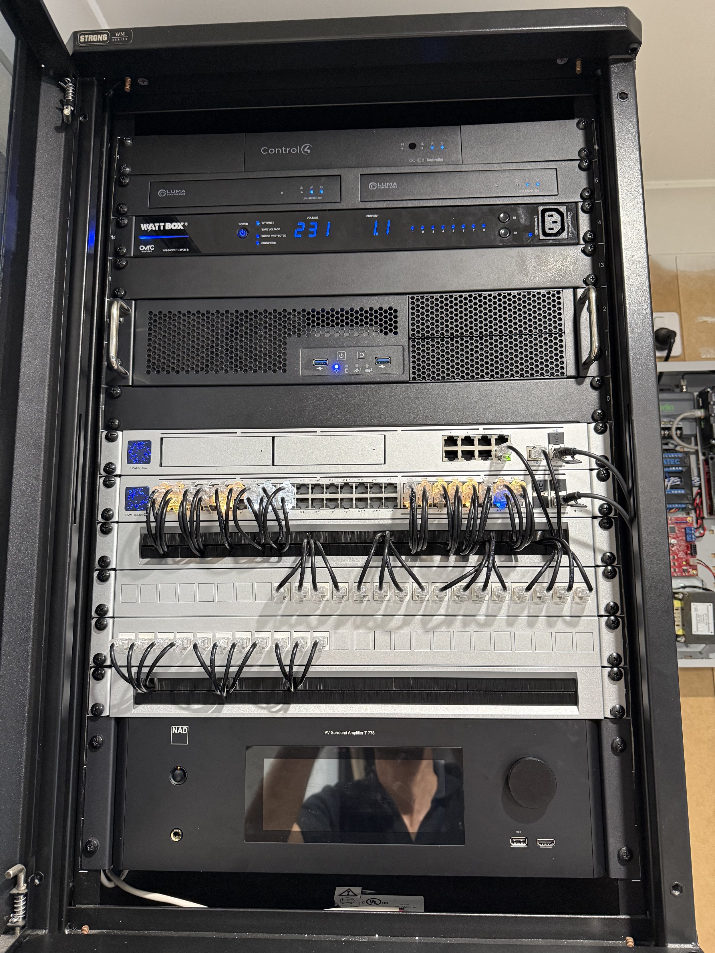 Server rack with audio and network equipment including Control4, WattBox, and NAD amplifier.