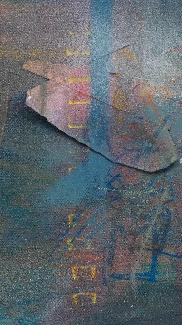 A close up detail photo of “Blue Umbrella” artwork.   A torn piece of paper on an abstract colorful background with splashes of yellow, blue, and orange paint.