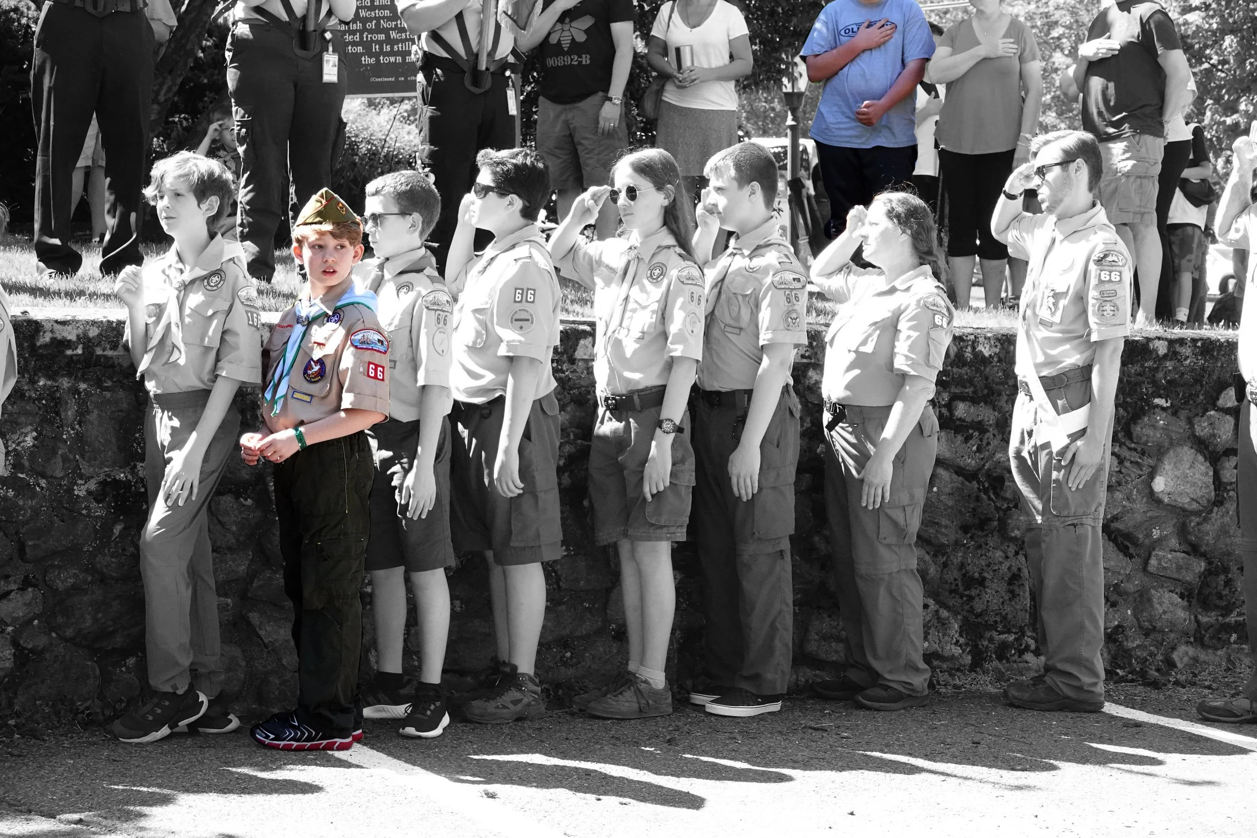 The touch of color works best when it calls the viewer’s attention to a significant aspect of the photo. Here, all the kids are saluting except the one in color facing the camera;  and check out the blue-shirted lad in the upper row offering a substi