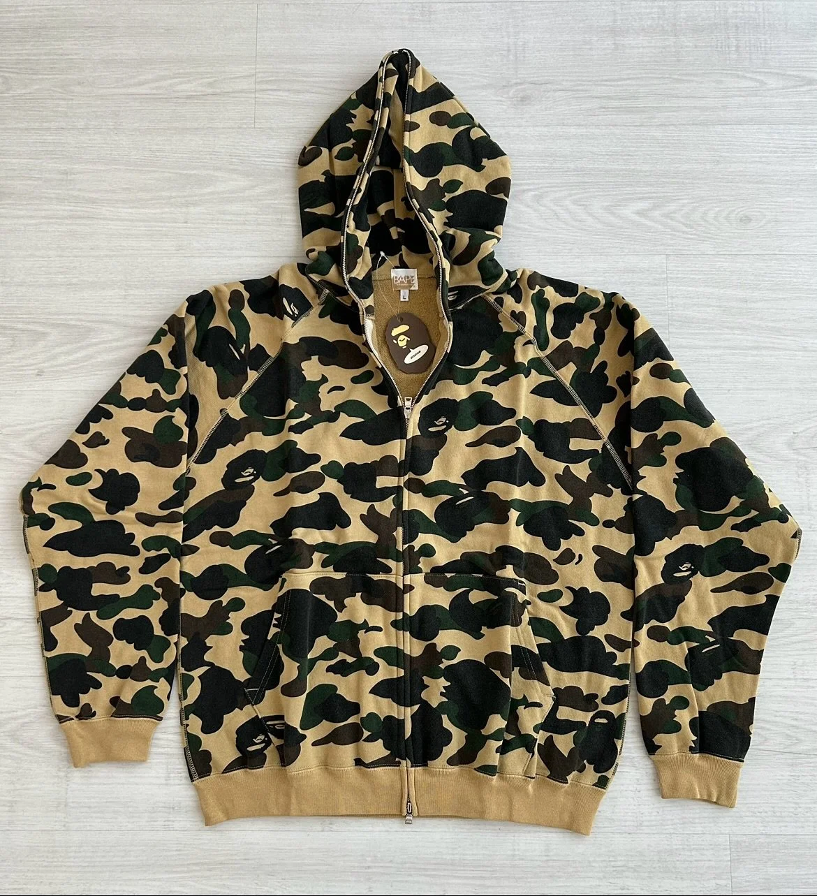 Second edition original A Bathing Ape 1st yellow camo fullzip hoodie on display.

The sunshine yellow base gives a playful twist to the brand&rsquo;s early camouflage motif, turning a utilitarian pattern into a streetwear icon.

Design wise, the 1st 