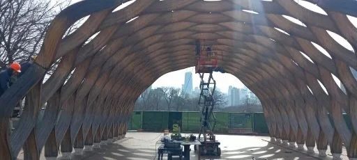 Wooden arched pavilion with construction equipment inside