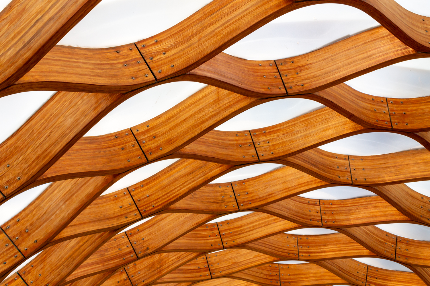 Curved wooden beams forming a wave pattern against a white background.