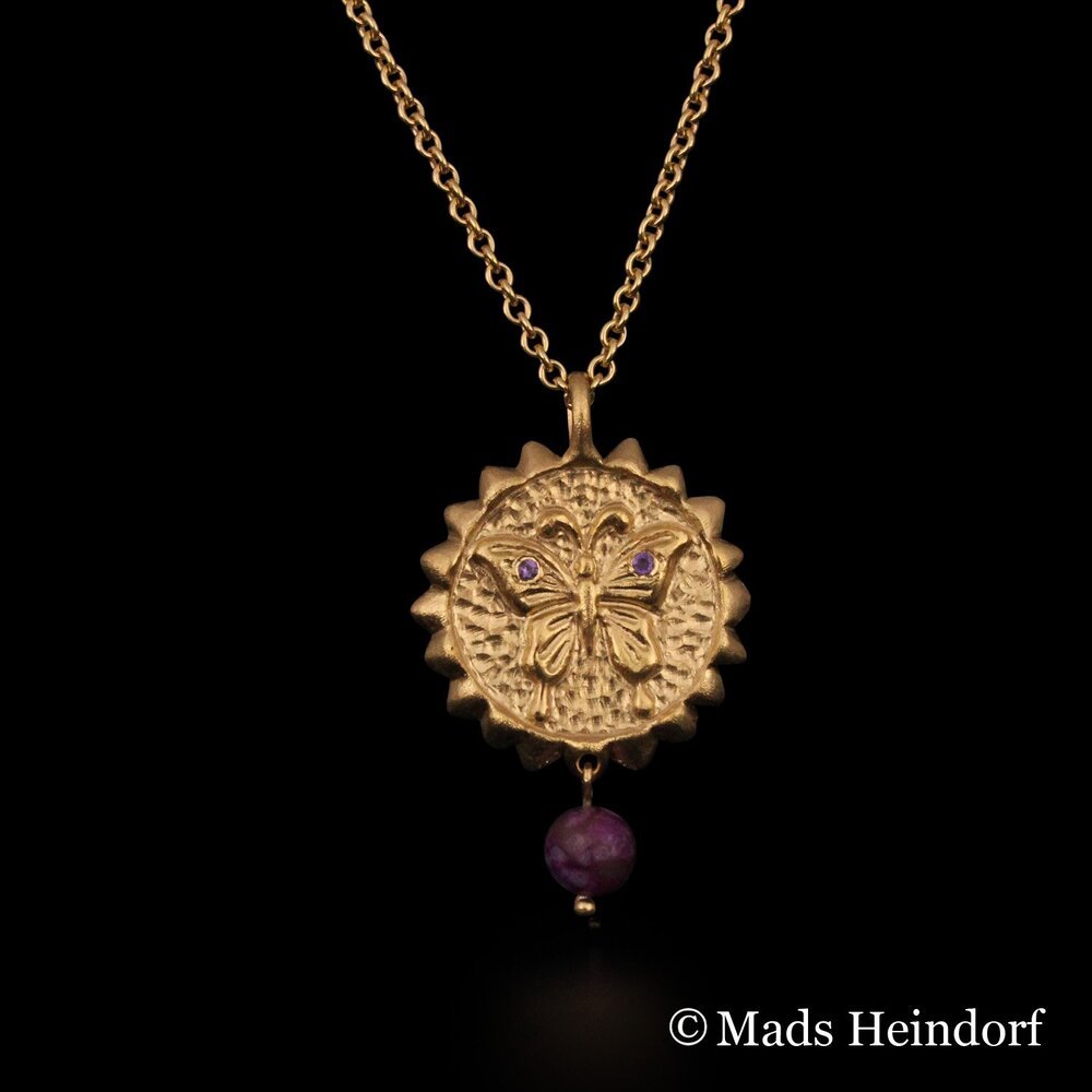 Håndlavet halssmykke af 18K rødguld med 3 facetslebne lilla ametyster og 1 lilla stenperle af sugilit fra kollektionen chakra af Guldsmed Heindorf.
