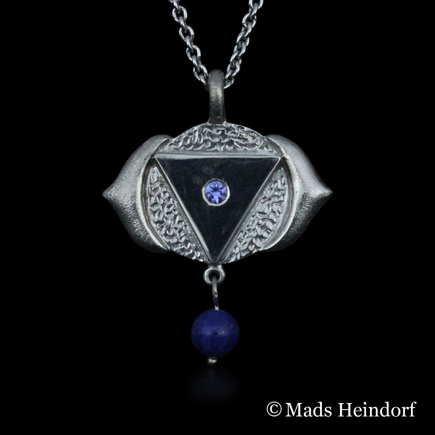 Håndlavet halssmykke af sterling sølv med 3 facetslebne indigo tanzanier og 1 blå stenperle af Lapis Lazuli fra kollektionen Chakra af Guldsmed Heindorf.