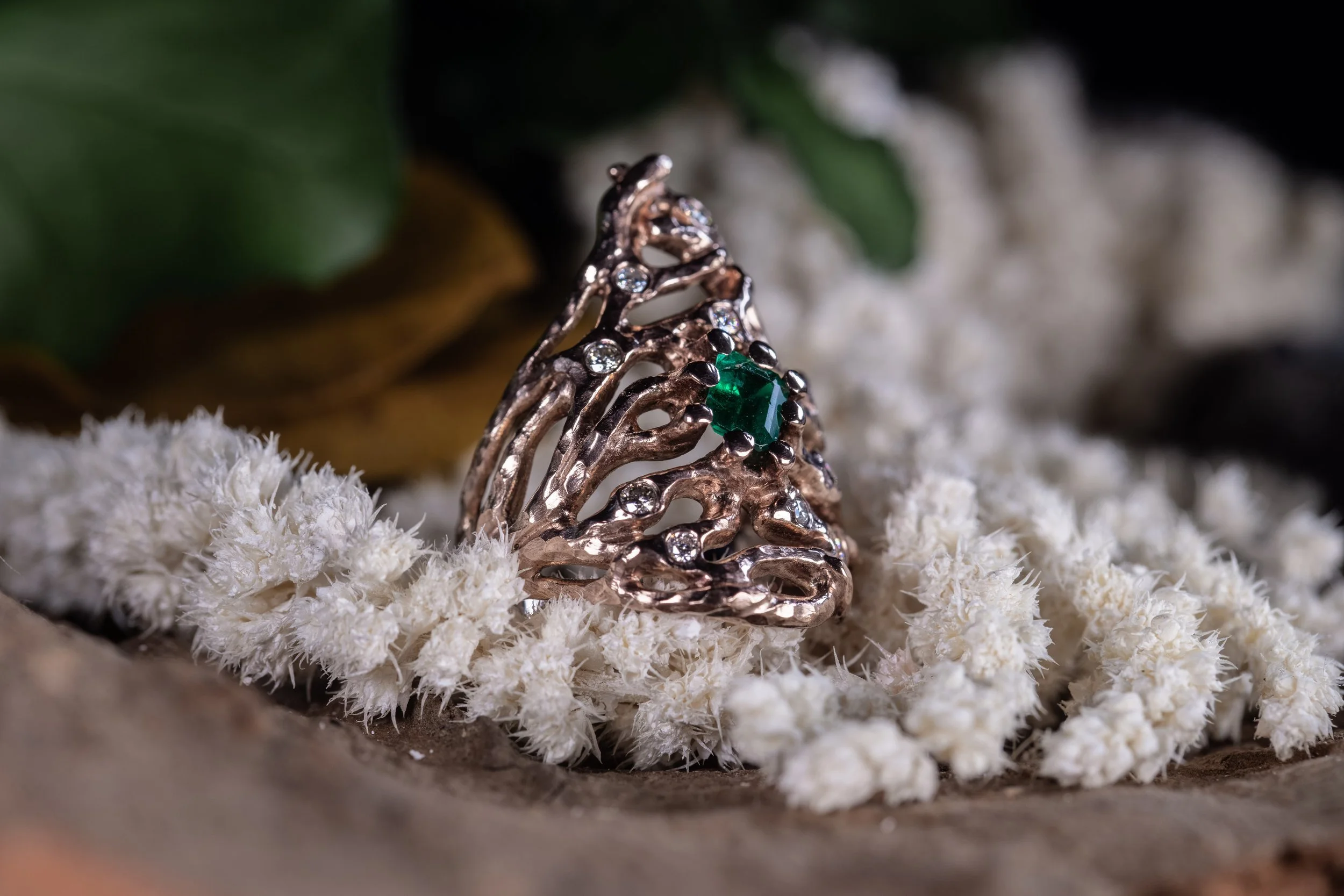 Håndlavet fingerring af 18K rosaguld med 1 facetsleben grøn smaragd på 0,62 carat og 10 brillantslebne diamanter fra kollektionen Skovkrat af Guldsmed Heindorf.