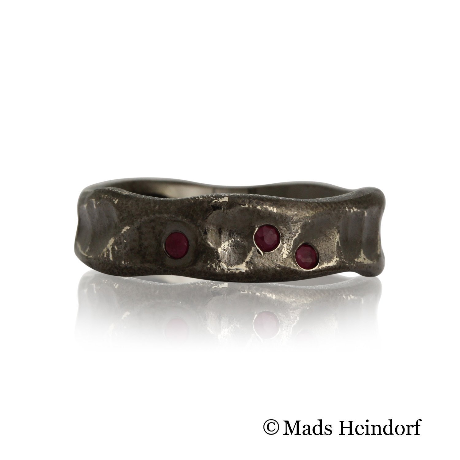 Håndlavet fingerring af sterling sølv med 3 facetslebne røde rubiner på 0,06 carat river LC med excellent slib fra kollektionen Trolde Smykker af Guldsmed Heindorf.