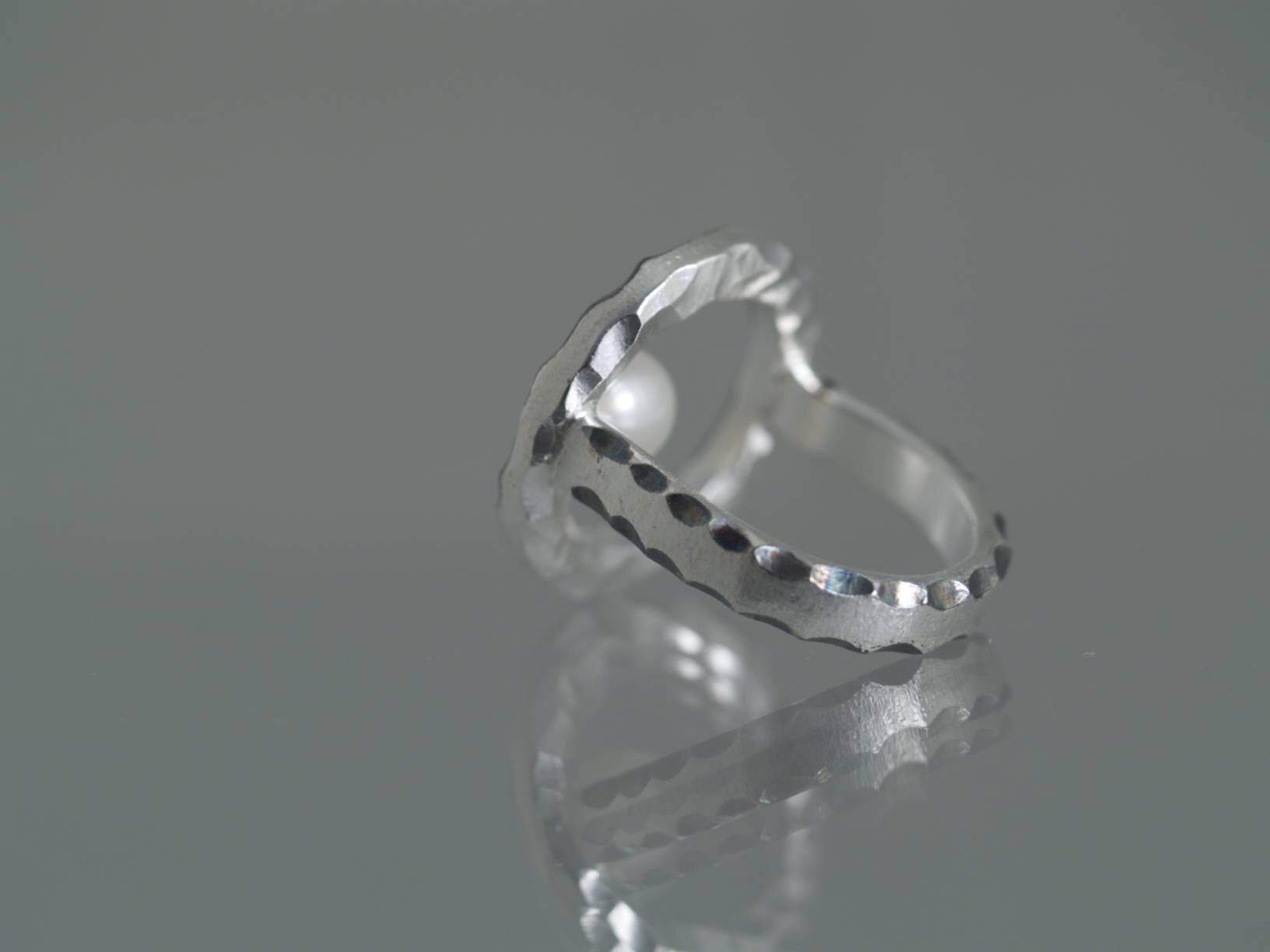 Håndlavet fingerring af sterling sølv med oxyderinger og akoya perle fra kollektionen Cirklen af Guldsmed Heindorf.