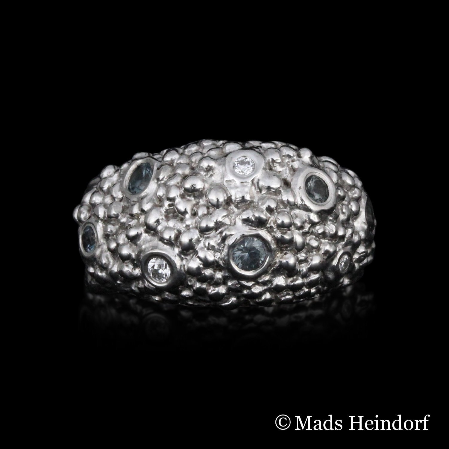 Håndlavet fingerring af 18K hvidguld med 5 blålige spineller på i alt 0,28 carat og 3 brillantslebne diamanter på i alt 0,06 carat fra kollektionen Myriader af Guldsmed Heindorf.