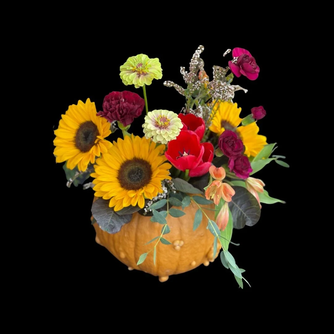 Sunflowers, zinias and more arranged inside a pumpkin