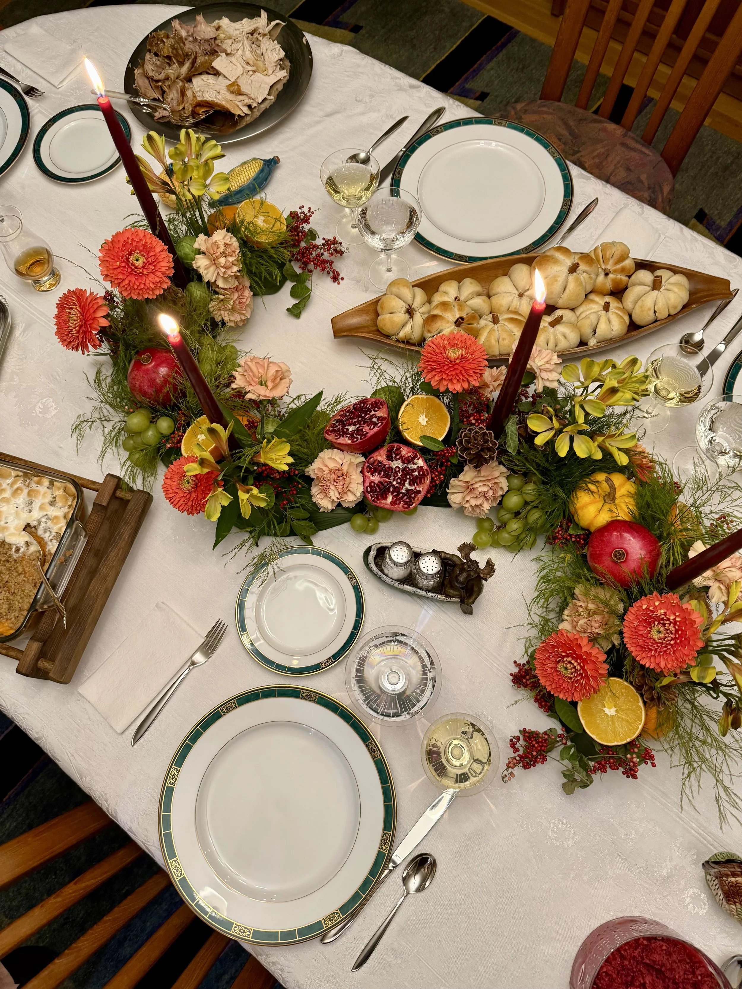 Thanksgiving curved centerpiece with flowers, fruit, and candles