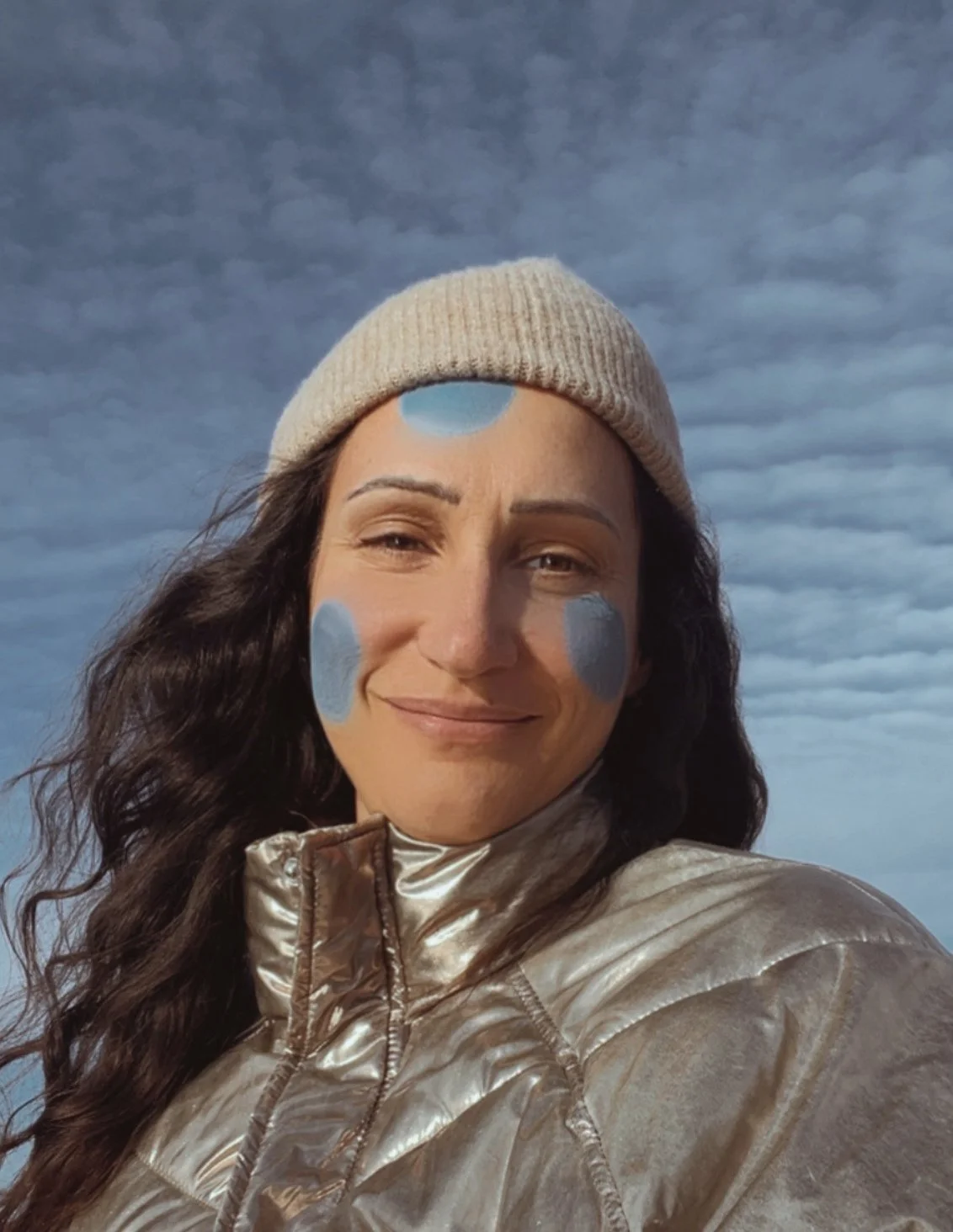 Mathilde Greuzat, illustratrice jeunesse, portrait avec des touches de gouache bleue sur le visage