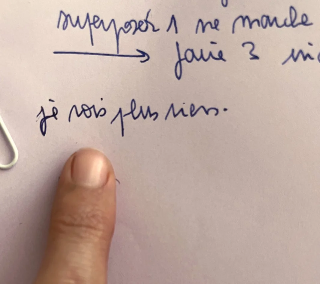Gros plan sur un mot écrit à la main de manière illisible par l'illustratrice Mathilde Greuzat, un doigt posé dessus, illustrant la fatigue visuelle après une longue session de dessin intense.⁠