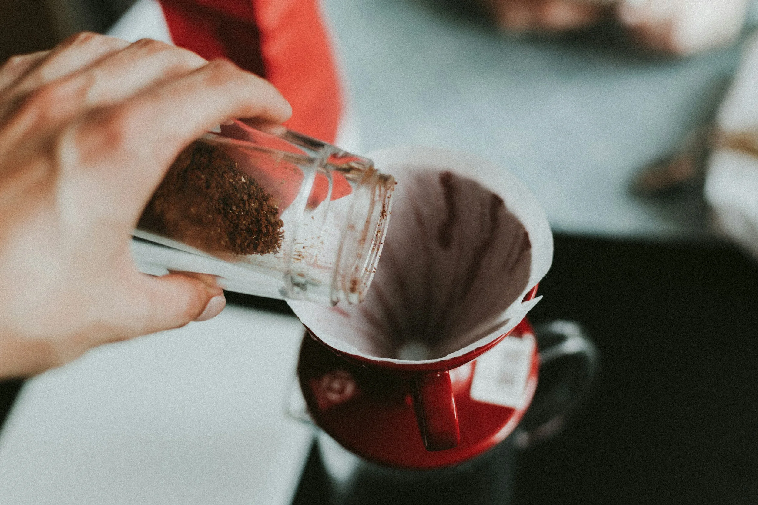 A man pouring and measuring the weight of his coffee for his pour over