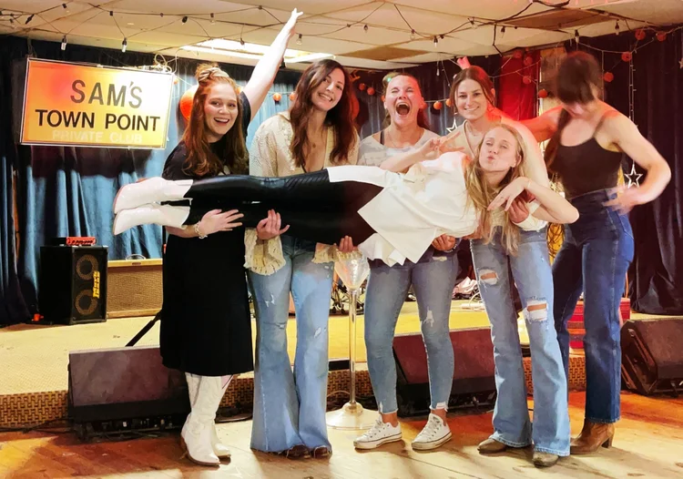 A bachelorette crew laughing at a line dance lesson at an Austin honky-tonk