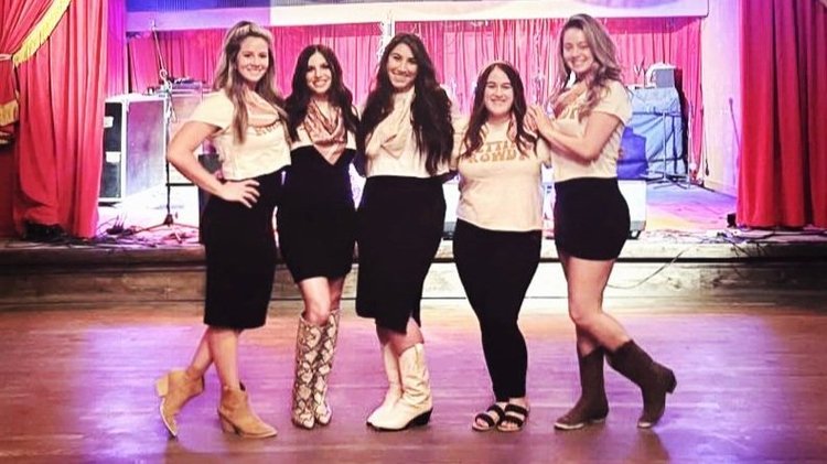 A bachelorette crew on stage at an Austin honky-tonk