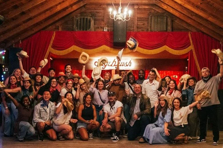 A large corporate group celebrating a line dance lesson at Sagebrush in Austin