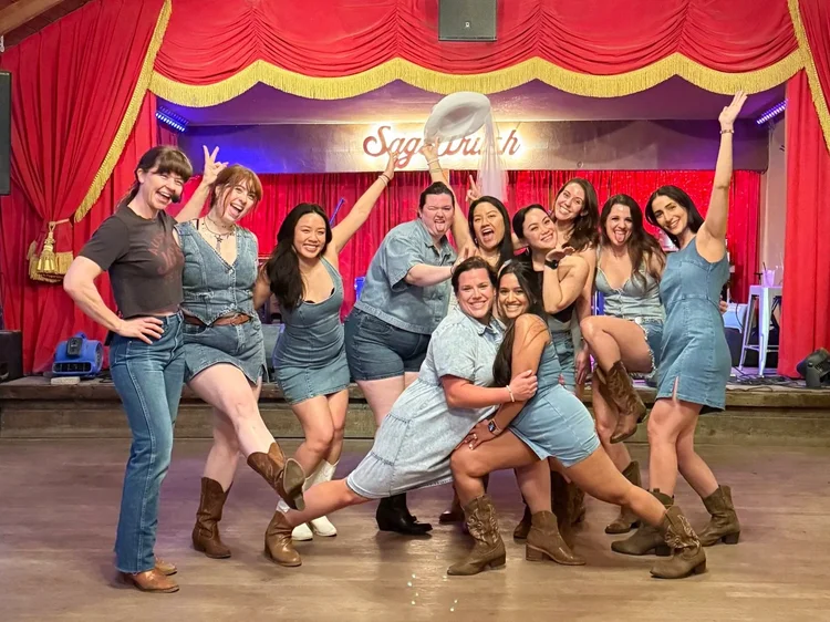 Bachelorette group leaning together on the Sagebrush honky-tonk stage
