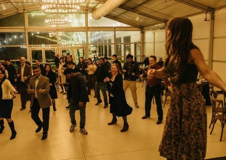 An instructor teaching a large corporate group to line dance at an Austin event