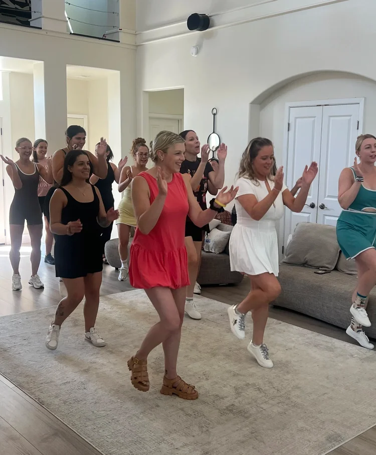 Bachelorette group celebrating with arms up at an Austin Airbnb line dance lesson