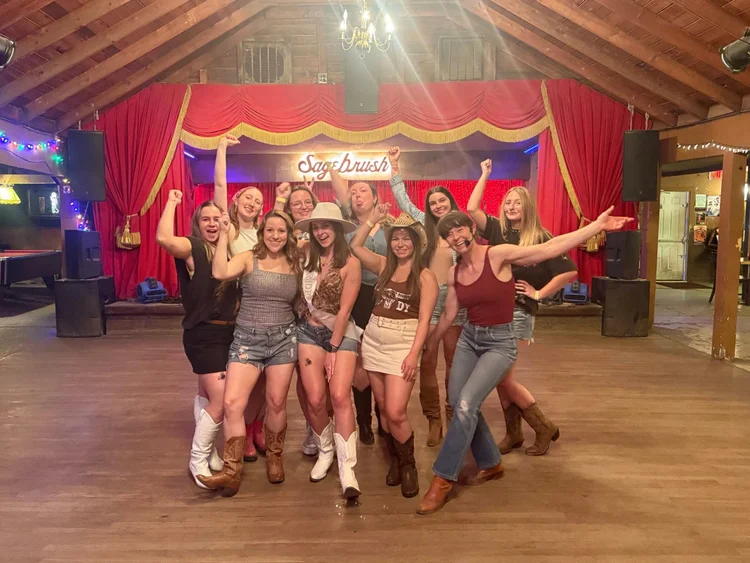 Bachelorette party posing on the red-curtain stage at Sagebrush in Austin