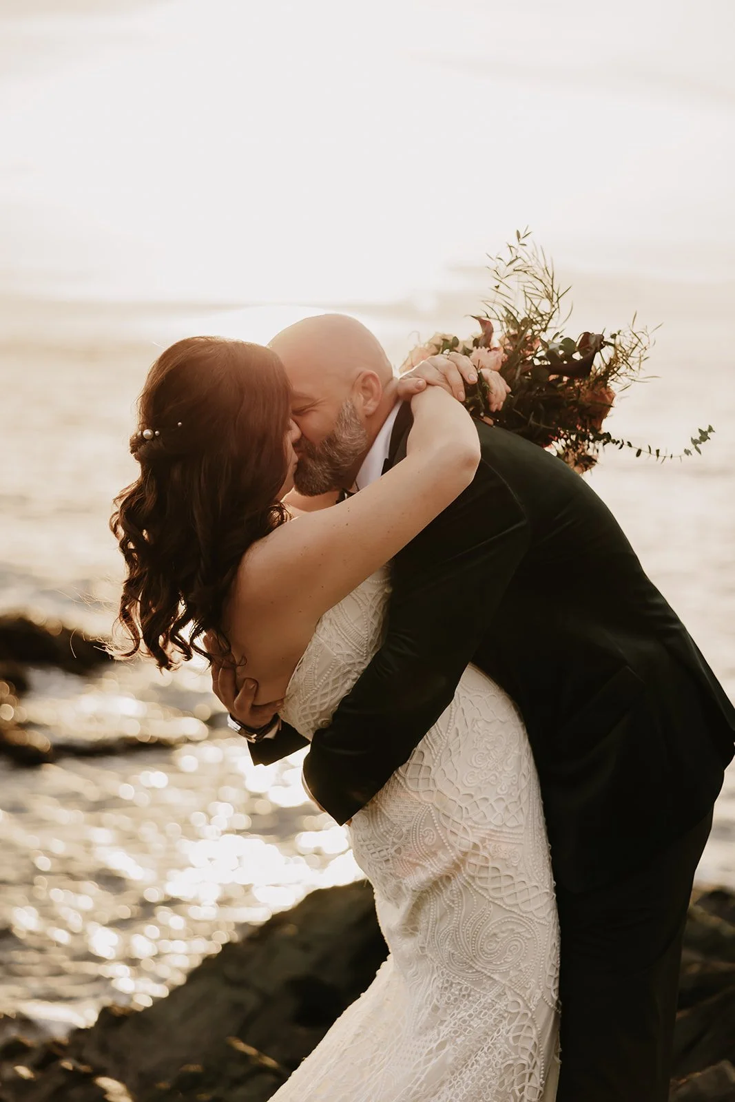 Newlyweds kiss on rocky BC coast – all-inclusive Vancouver elopement package.