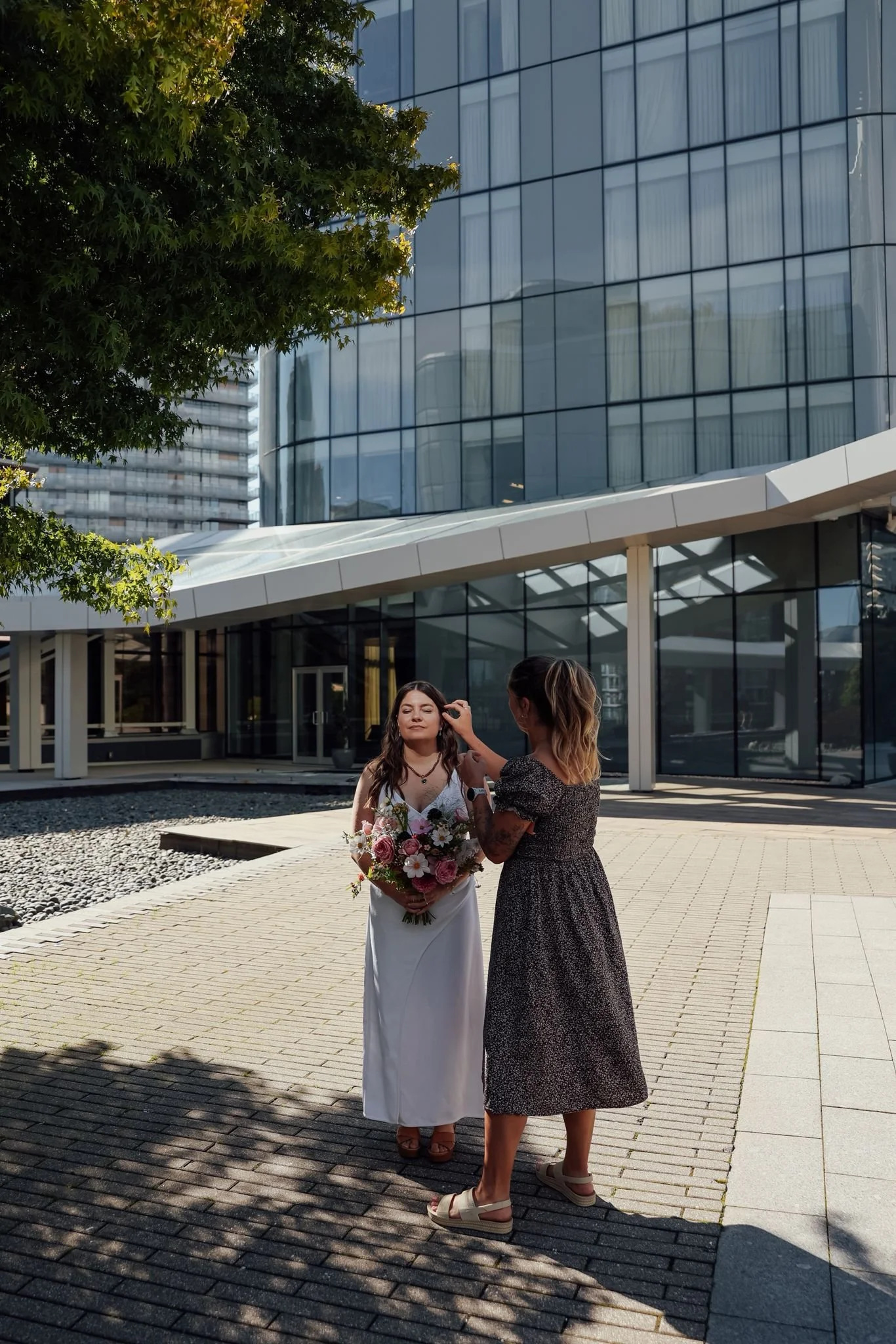 Wedding planner Jocelyn Bacon helping a bride fix her hair before a photo