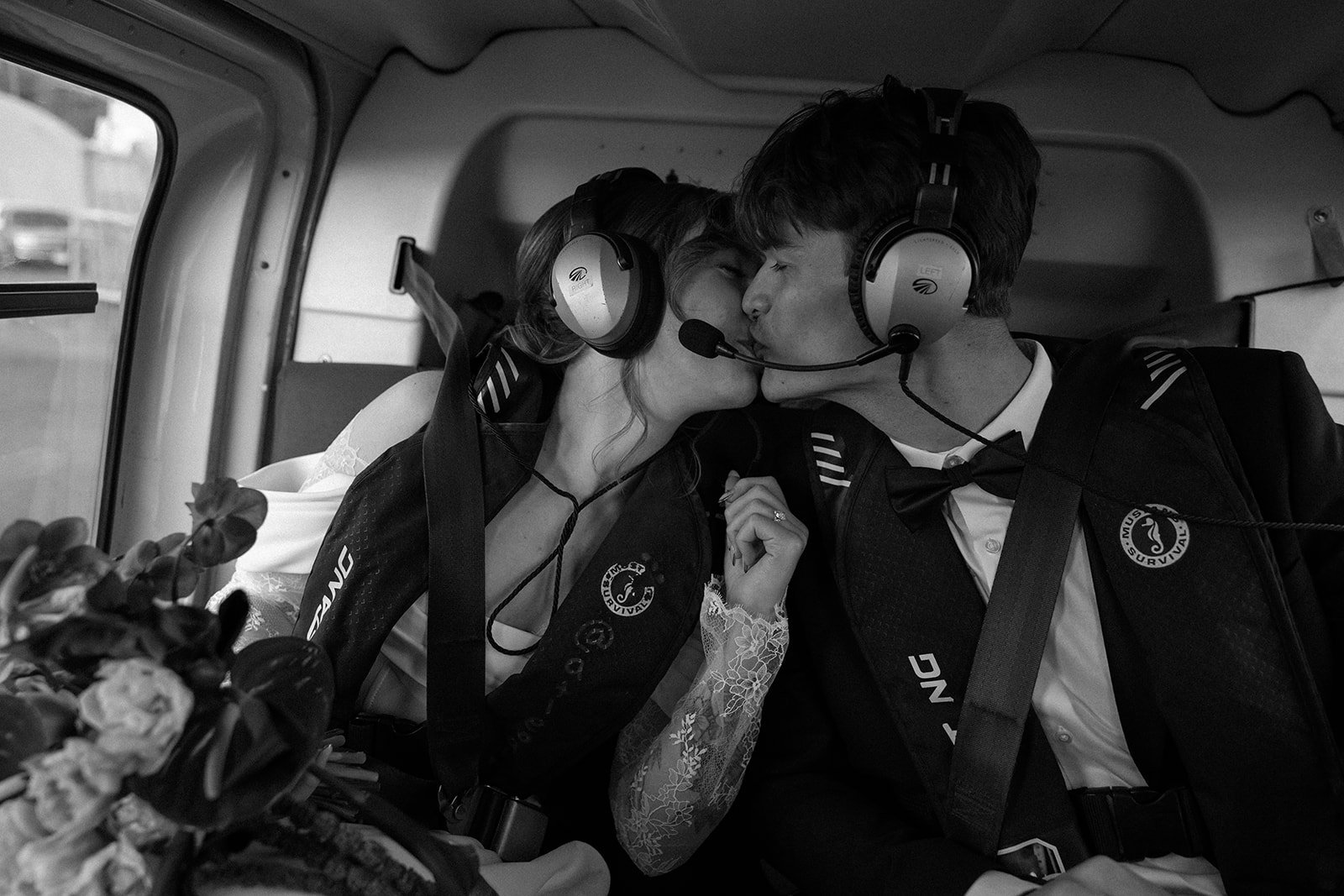A bride and groom kissing in a helicopter during their helicopter elopement in Tofino