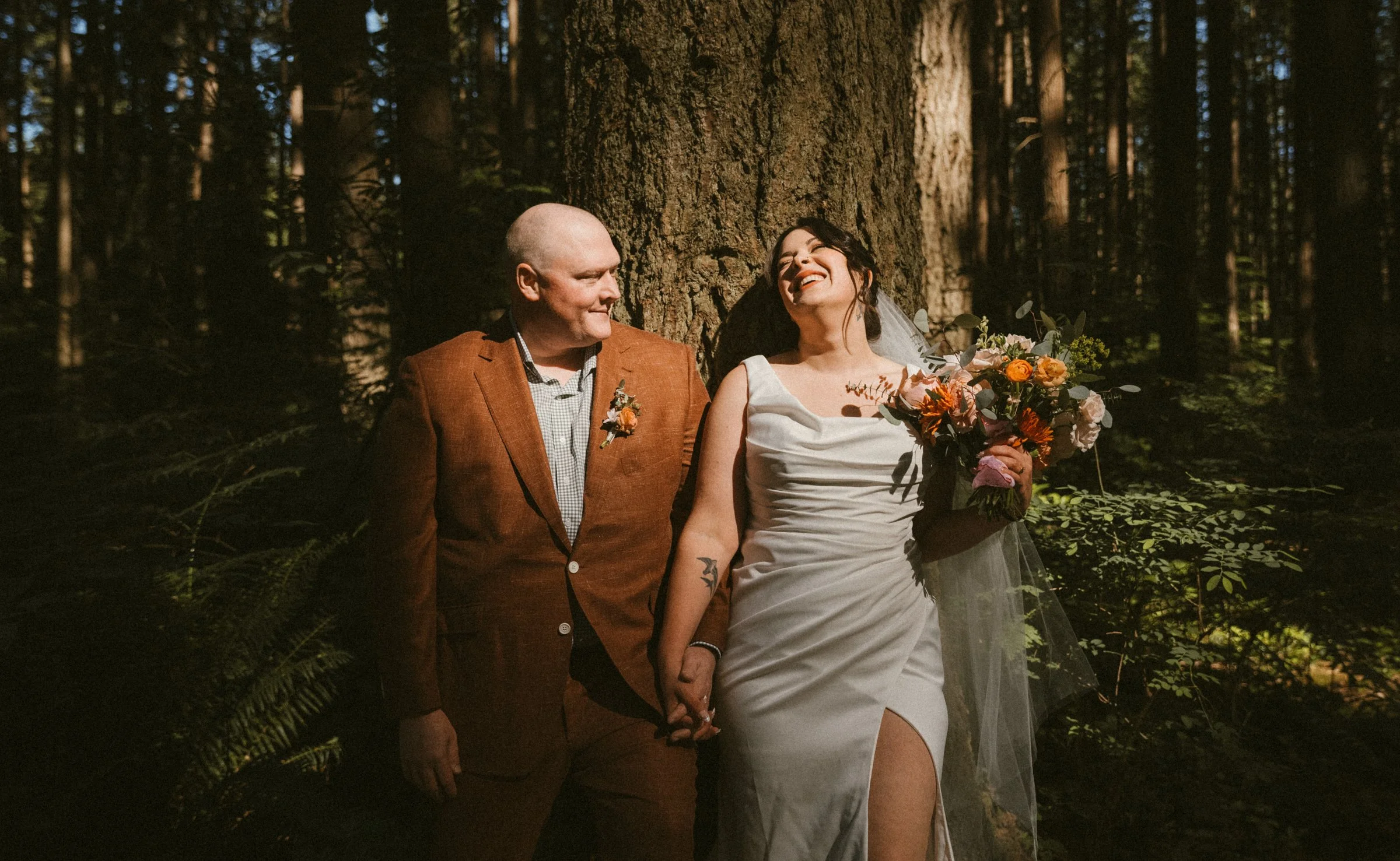 A happy couple under a tree during their BC elopement