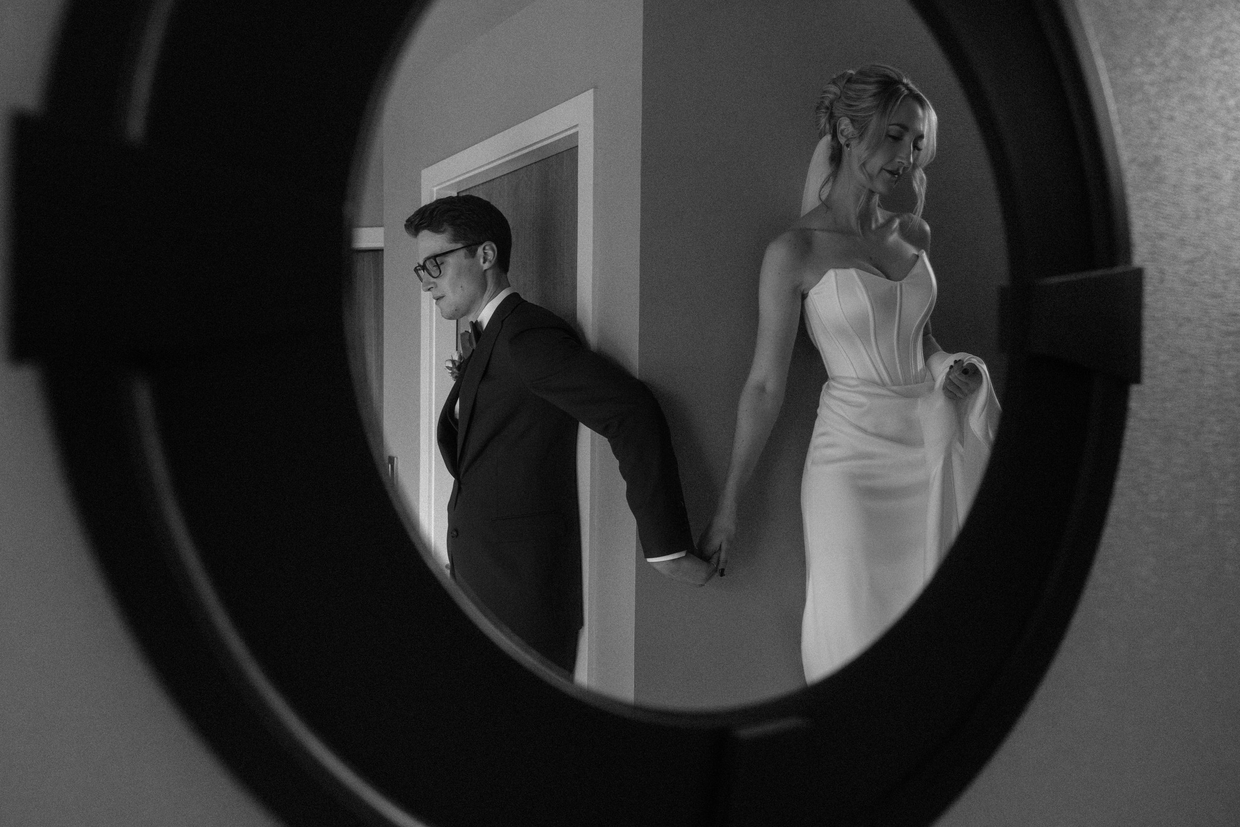 Couple holding hands in a mirror during their elopement