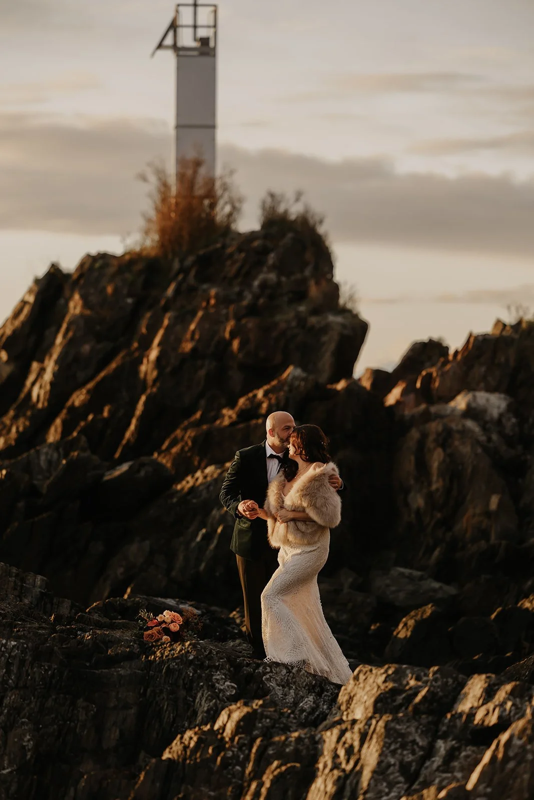 Groom kisses bride on BC rocky coast – Vancouver elopement planner package.