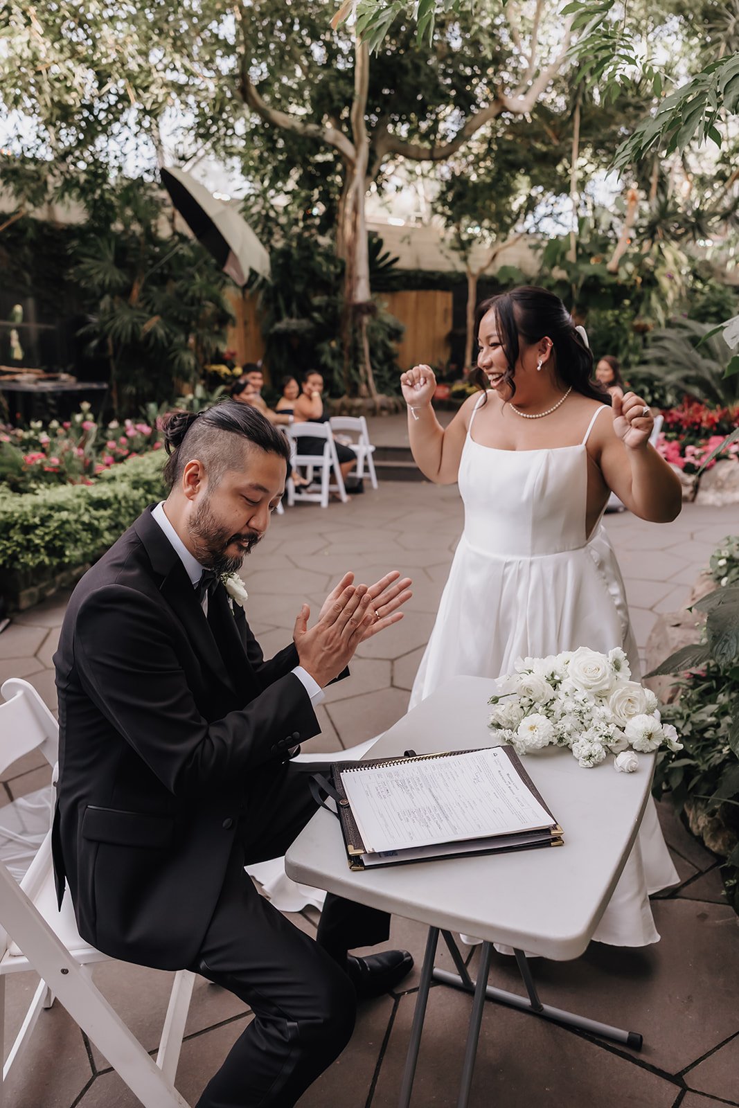 A happy bride and groom signing their marriage license during their BC elopement