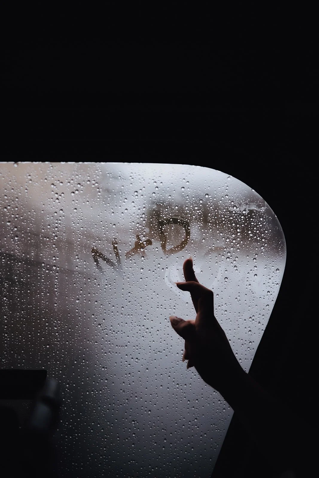 Bride writes initials in foggy window during Douglas Island helicopter elopement.