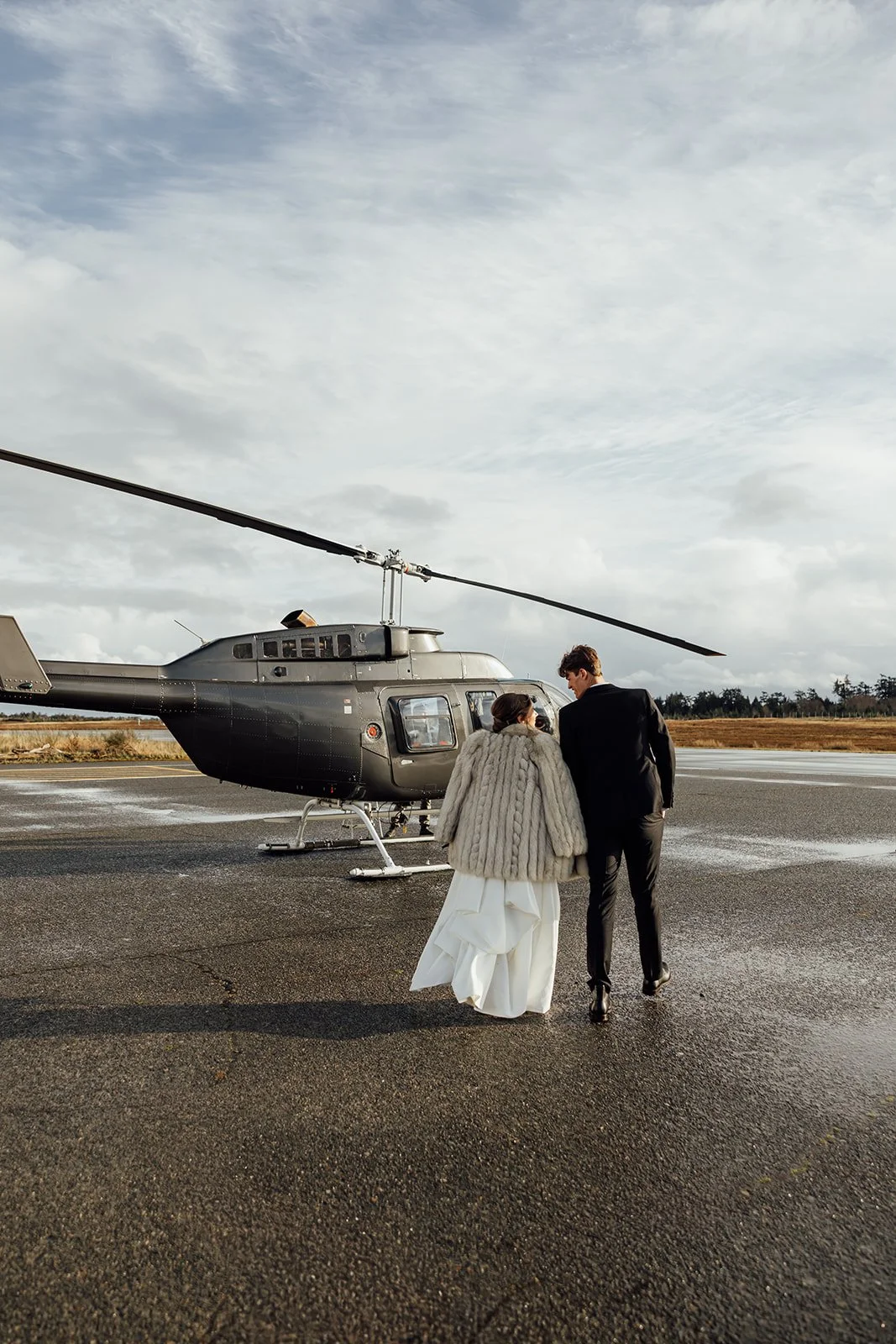 Ready to elope, a couple walking toward a helicopter