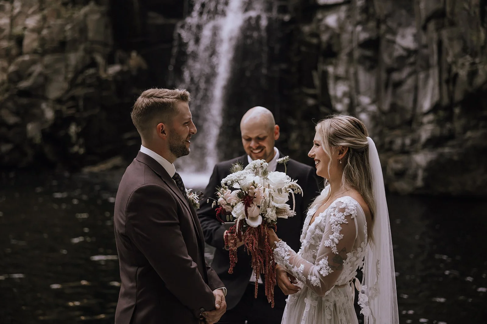 An elopement ceremony in front of a waterfall